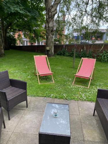 CheswardineSTABLE COTTAGE的两把椅子和一张位于院子的茶几