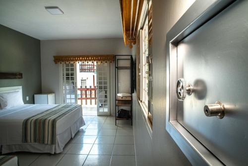 皮雷诺波利斯Villaê Pousada的一间卧室配有一张床,一扇门通往阳台