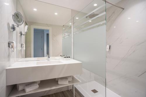 波尔图HF伊帕内玛公园的白色的浴室设有水槽和玻璃淋浴间。