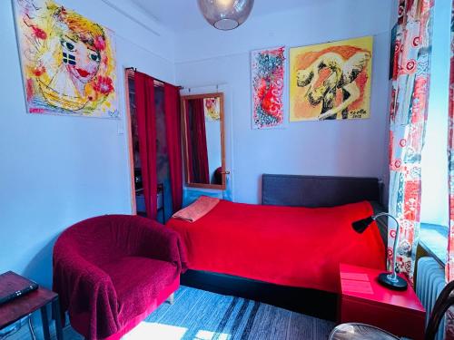马尔默The Sunset的一间卧室配有红色的床和椅子