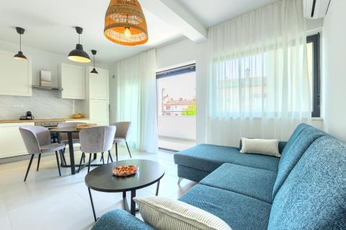 罗维尼Apartments La Scogliera Rovinj的客厅配有蓝色的沙发和桌子