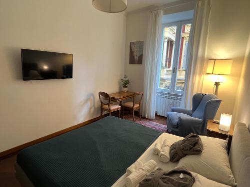 罗马Torlonia Rooms的一间卧室配有一张床、一张桌子和一台电视。