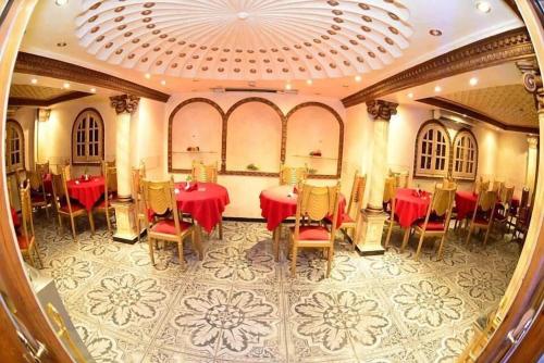 开罗The New Garden Palace Hotel的一间设有红色桌椅和天花板的用餐室