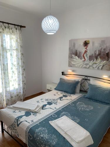 米克罗斯雅洛斯ΜΕΤΑΧΑ的一间卧室配有一张带蓝色棉被的床