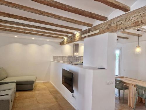 代尔特布雷Villa Barracot的厨房以及带白色墙壁和木梁的起居室。