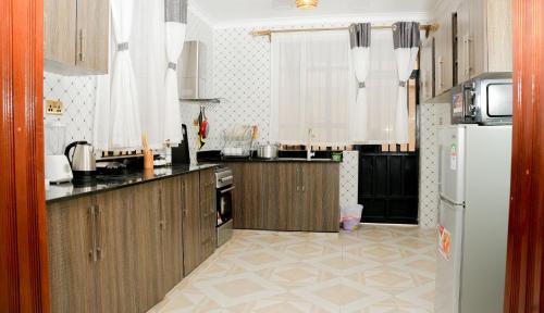 奈瓦沙Advent Homes on Moi South lake road, Villa View Estate的厨房配有木制橱柜和白色冰箱。