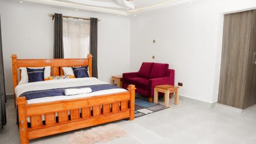 奈瓦沙Advent Homes on Moi South lake road, Villa View Estate的一间卧室配有木床和红色椅子