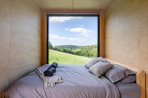 坎特伯雷Secluded Offgrid Cabin w/ Sunset View & Fireplace的一张位于带大窗户的房间内的床铺