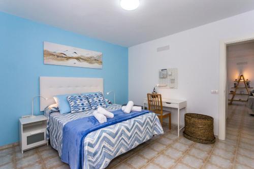 宏达海滩Eslanzarote ECO TANA HOUSE, super wifi, Tv satélite, Bbq的一间卧室配有一张床、一张桌子和一把椅子