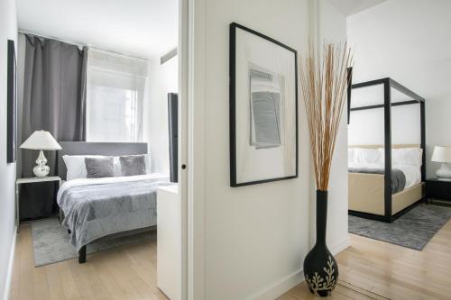 纽约Modern 2BD in Midtown with Washer and Dryer in-unit的卧室配有一张床,地板上设有花瓶