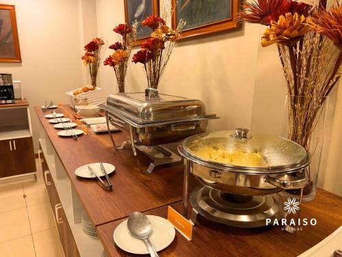 齐克拉约Hoteles Paraiso CHICLAYO的厨房配有带鲜花的桌子的自助餐