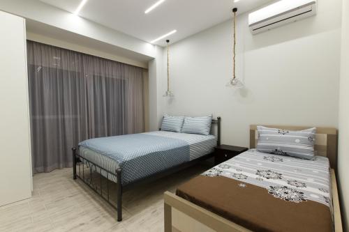 萨兰达Vila SHAKAJ的客房设有两张床和窗户。