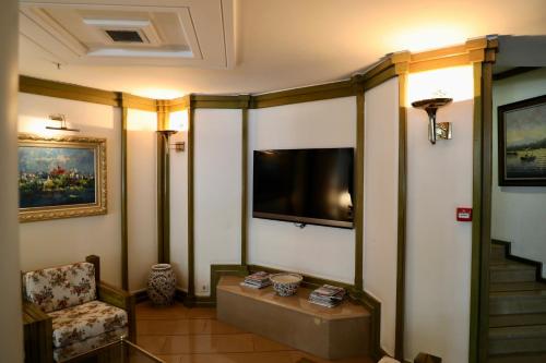 伊斯坦布尔伊斯坦布尔皇家酒店的客厅设有壁挂式电视和椅子