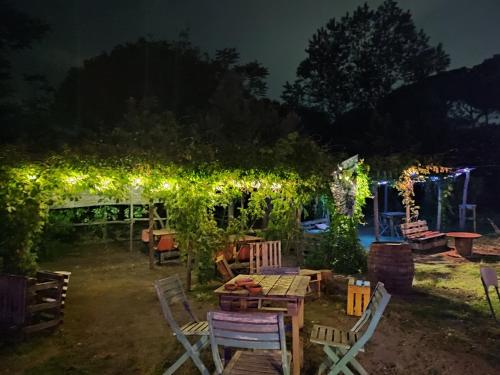 托雷德尔格雷科Brandito's的花园,晚上设有凉棚和椅子