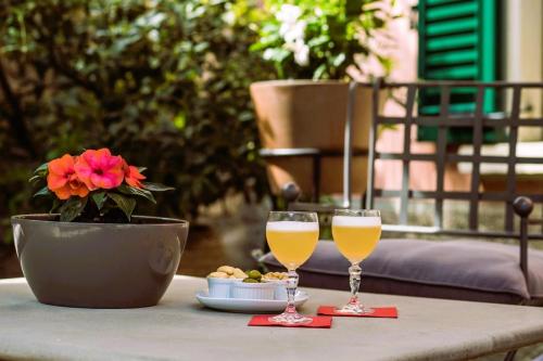 贝加莫瓦莱塔勒莱斯酒店的两杯酒和一盘桌上的食物