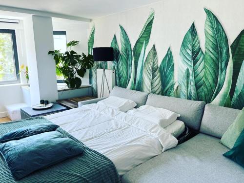 奥斯坦德Sfeervolle vakantiewoning aan zee的一间卧室配有一张床和一张木叶壁画