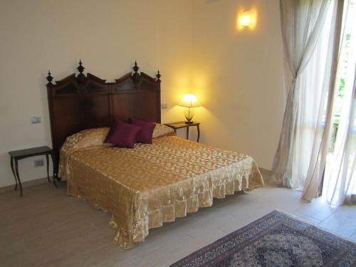 萨尔扎纳B&B Al Calcandola的一间卧室配有一张带木制床头板的床