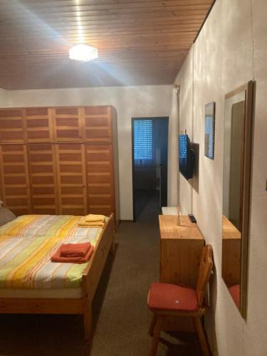 锡默拉特Waldblick的卧室配有1张床、1张桌子和1把椅子
