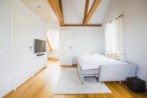 沃鲁Jüri tn Apartment B的一间白色卧室,配有床和电视