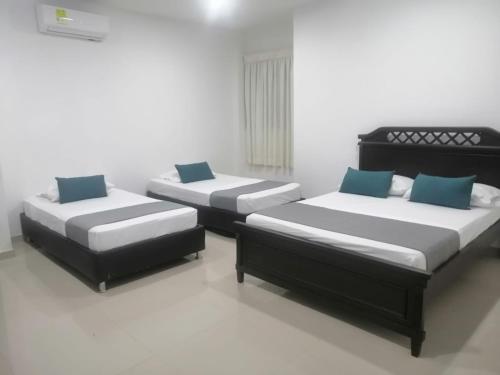库库塔Aveiro Hotel的配有两张床的客房内。
