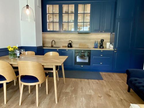 格丁尼亚Apartament przy plaży Willa Redłowo的厨房配有蓝色橱柜和桌椅