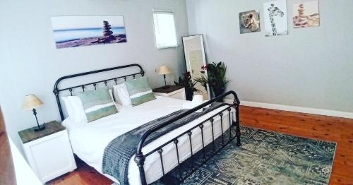 德班Rose Holiday Home的一间卧室配有带白色床单和枕头的床。