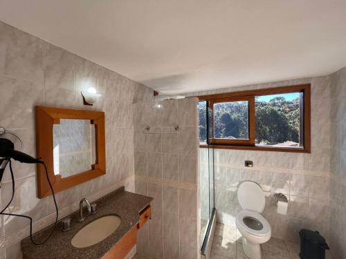 蒙特韦尔迪Banyvas Chalés的一间带卫生间、水槽和窗户的浴室