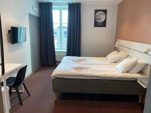 耶夫勒Ahlgrens Hotell Bed & Breakfast的一间卧室配有一张床、一张书桌和一个窗户。