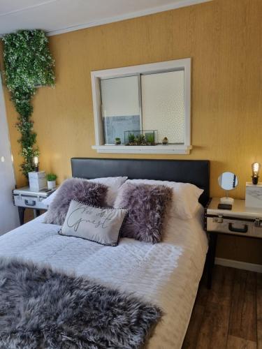 安特里姆Firbog Nook的一间卧室配有一张带毛皮枕头的床和窗户。