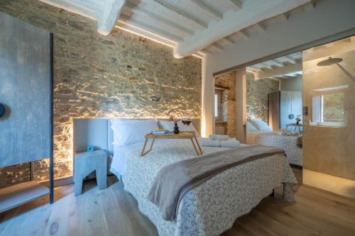 科尔恰诺Forma Your Boutique Suite的一间卧室设有一张床和石墙