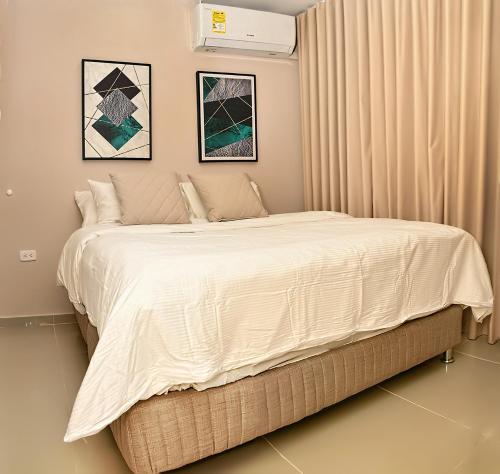 巴兰基亚De estreno, nuevo apto en Barranquilla的一间卧室配有一张带白色床单的大床