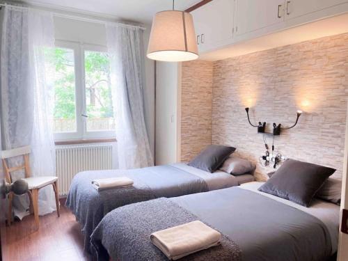 恩坎普Casa Andorrana - ¡A Pie de todo!的一间卧室设有两张床和砖墙