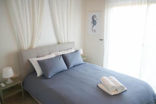 梅内乌Ocean Blue House 17的一间卧室配有蓝色的床和2条毛巾