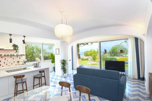 伊斯基亚OraBlu Exclusive Villas的一间带蓝色沙发的客厅和一间厨房