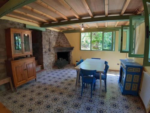 皮斯托亚Casa del Castagno: un nido nel castagneto的一间带桌椅和壁炉的用餐室