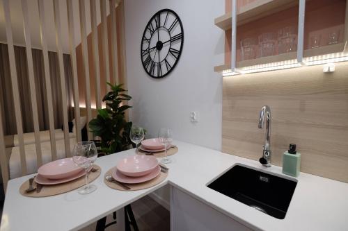 比亚韦斯托克Apartamenty Centrum的厨房配有水槽和墙上的时钟