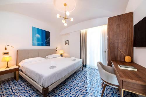 伊斯基亚OraBlu Exclusive Villas的酒店客房设有一张大床、一张书桌和一张书桌。