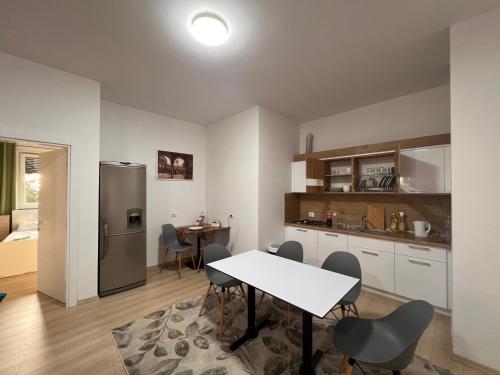 地拉那Kino Apartment的厨房以及带桌子和冰箱的用餐室