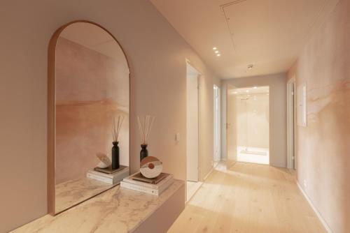 特罗姆瑟Vindlys Luxury Penthouse Apartment的走廊上设有大镜子和花瓶
