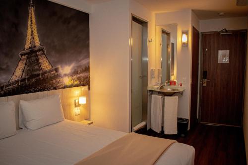 蒙特雷Hotel Hi! Guadalupe的一间卧室配有一张床铺,享有艾菲尔铁塔的景色