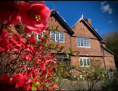 Stockton on TemeThe Old Rectory with Valley View的前面有红花的砖房