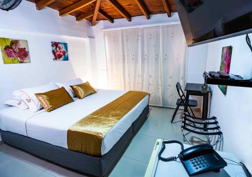麦德林Hotel Casa 10的一间卧室配有一张床和一部电话
