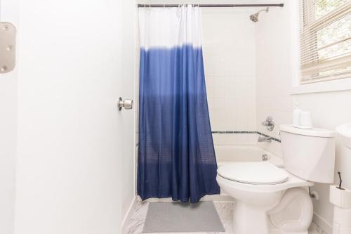 劳德代尔堡Studio Las Olas - Fort Lauderdale - 5 minutes walk to beach的浴室设有卫生间和蓝色的浴帘。