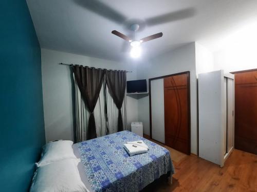 卡尚布Alvorada Guest House的一间卧室配有一张床和吊扇