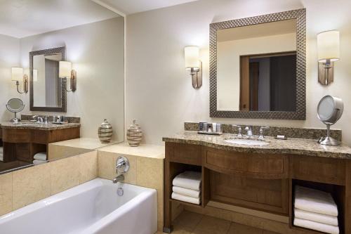 土桑图森派司JW万豪酒店的浴室设有2个水槽、浴缸和镜子