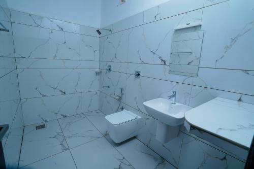 安加马尔伊KOTTACKAL NATURE INN的白色的浴室设有水槽和卫生间。