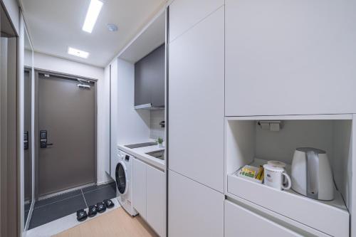 春川Chuncheon Bella Residence的白色的小厨房,配有洗衣机和烘干机