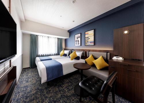 神户神户三宫方丹别墅酒店的一间酒店客房,配有一张床和一台电视