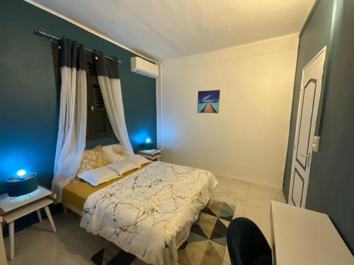 法兰西堡Résidence Peace & Joy的一间卧室配有一张蓝色灯床
