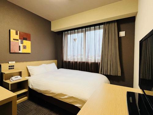 熊谷熊谷路途酒店 的酒店客房设有床和窗户。